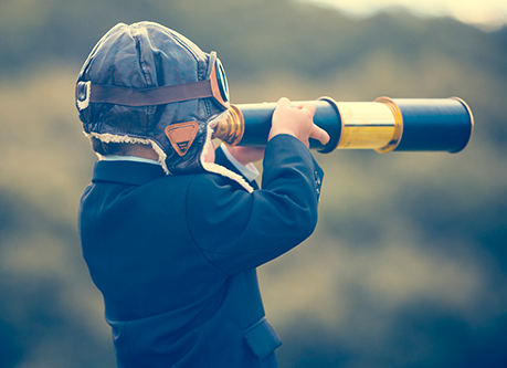 child looking though a telescope 